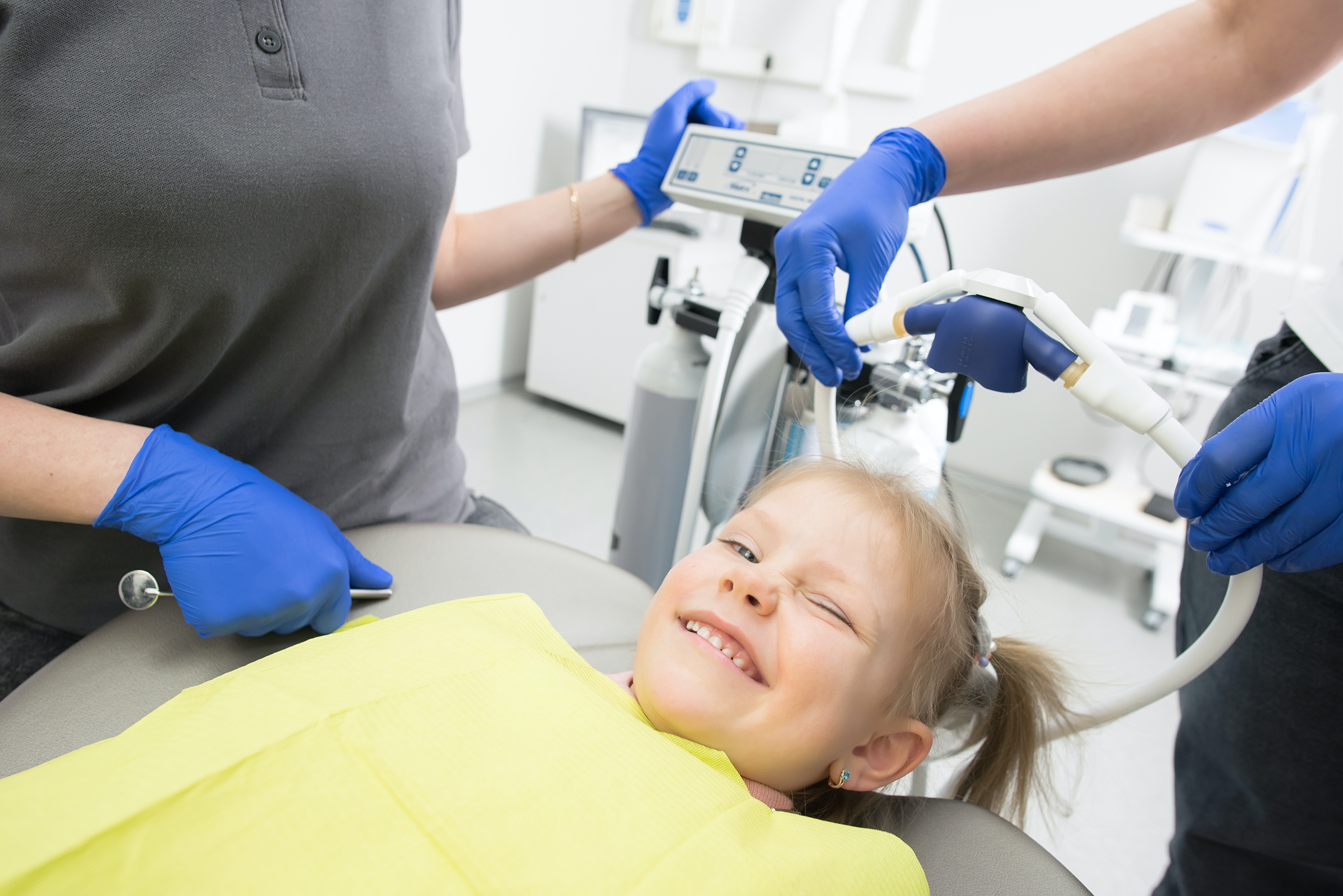 cute girl winking while getting a dental treatment